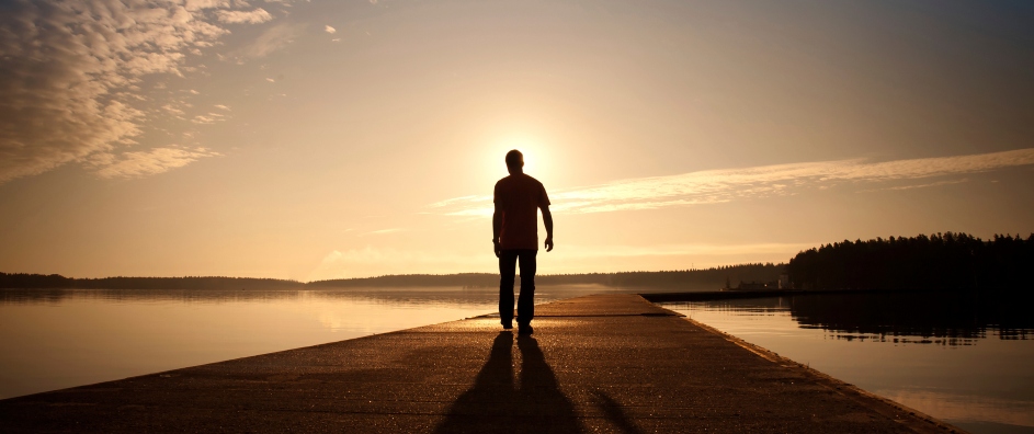 Man goes on concrete pier in the sunrise