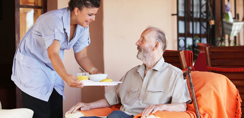 Careworker serving elderly man