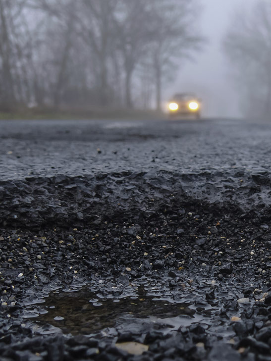 Car approaching pothole