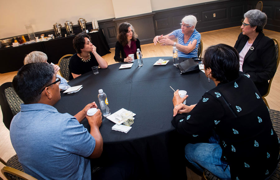 Speakers and attendees converse during a break at the recent Baha’i Chair conference about the equality of women and men.